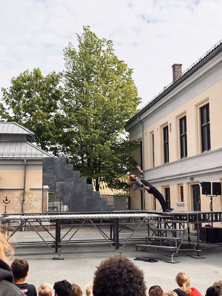 en person som gjør et triks på en trampoline foran en folkemengde