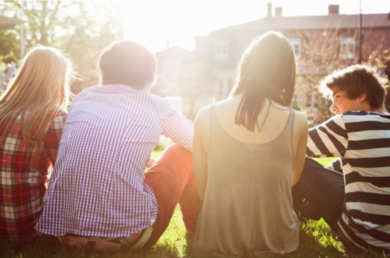 en gruppe mennesker som sitter på gresset