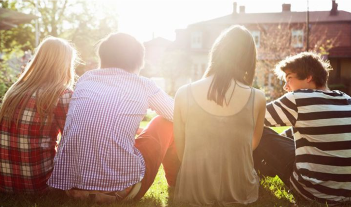 en gruppe mennesker som sitter på gresset