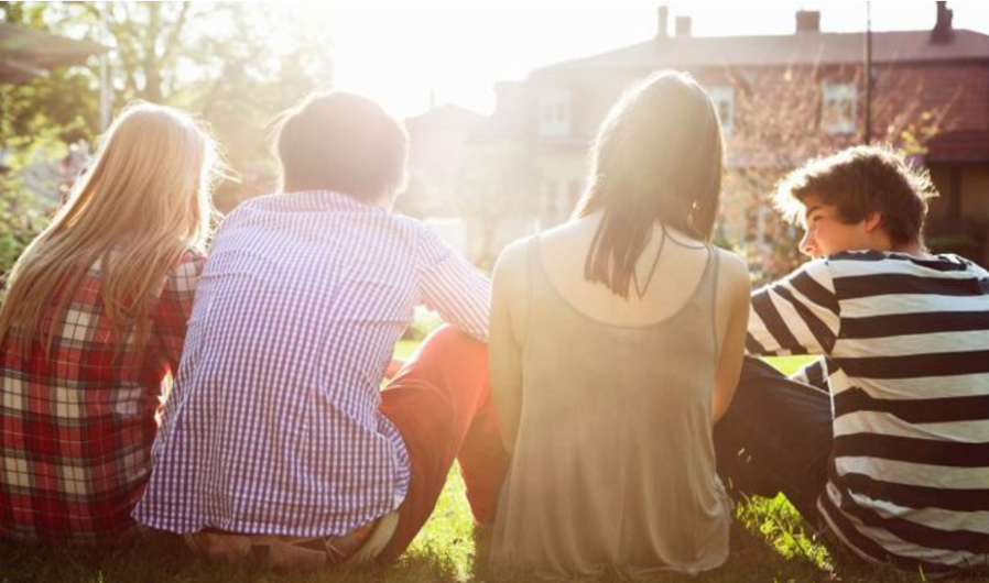 en gruppe mennesker som sitter på gresset