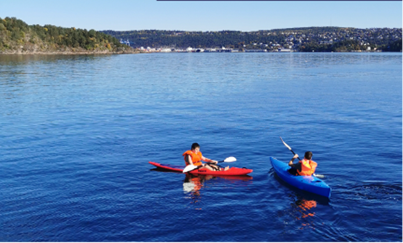et par personer i kajakk på en innsjø