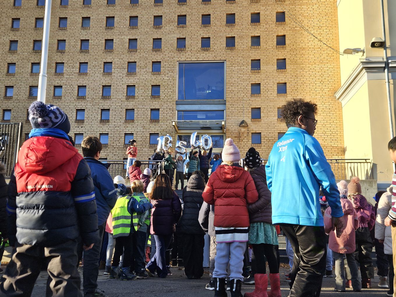 en gruppe mennesker som står utenfor en gruppe mennesker som står utenfor